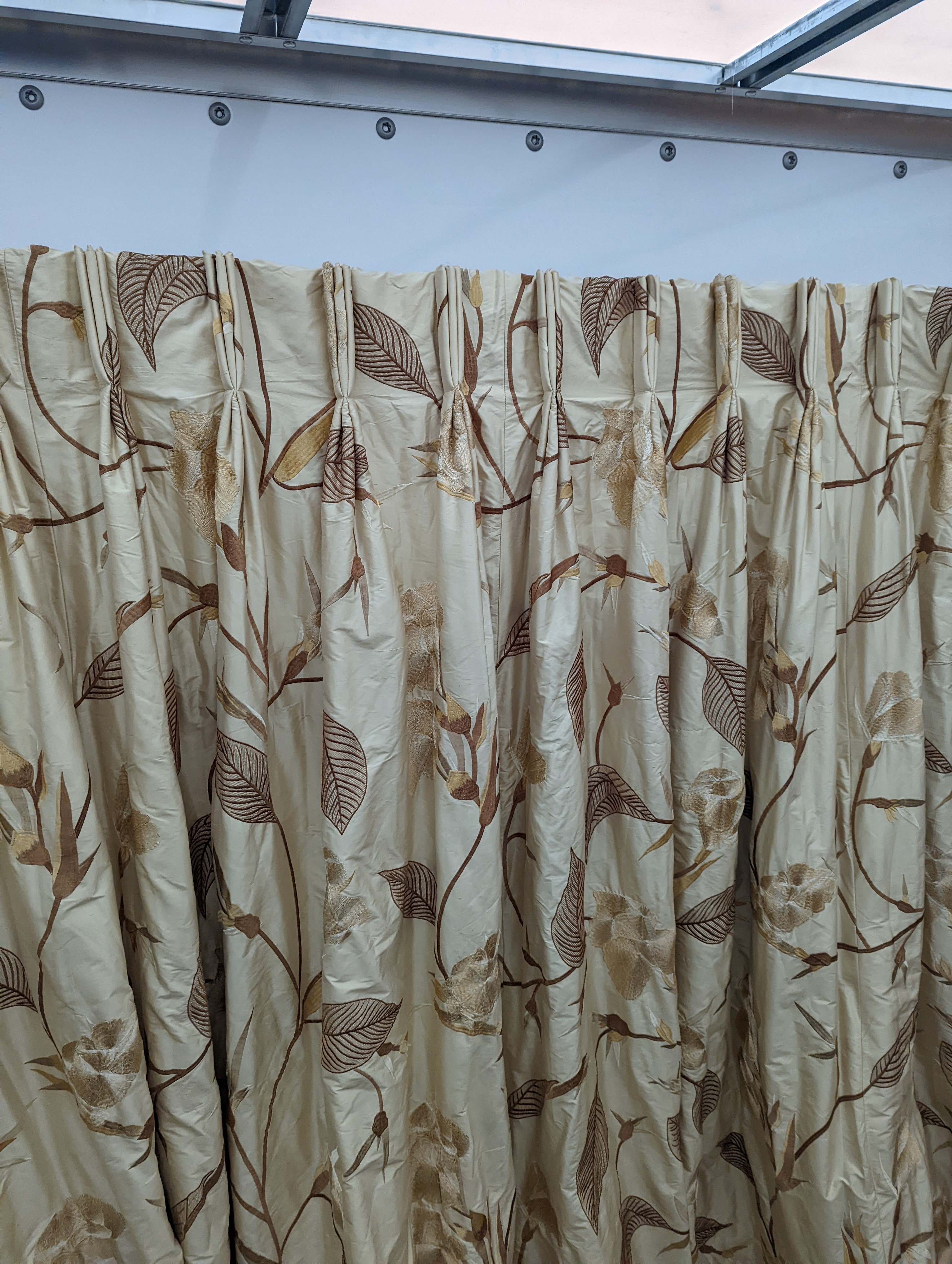 A pair of floral lined curtains. Approximate measurements: Width of top 230cm, Width of bottom 420cm Length 250cm